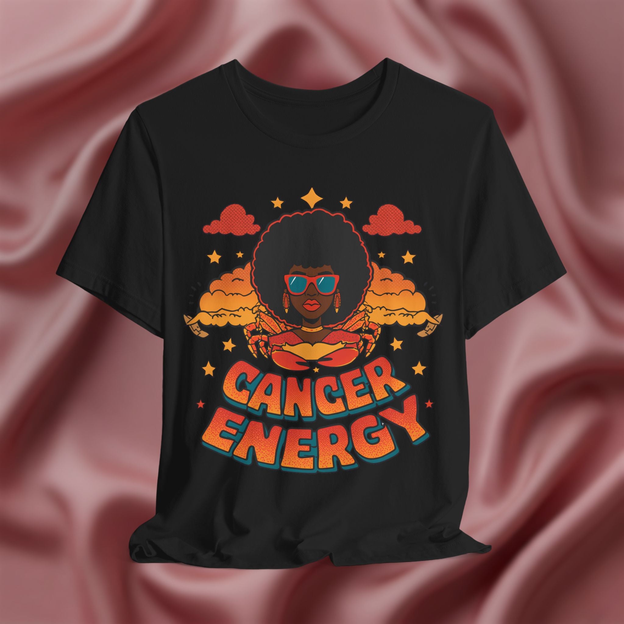 Black t-shirt with 'Cancer Energy' design on a pink fabric background