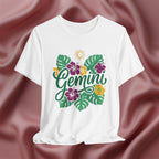White t-shirt with 'Gemini' design featuring flowers and leaves on a maroon fabric background