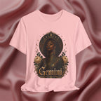 Pink t-shirt with a graphic design of a woman, flowers, and the word 'Gemini' on a pink fabric background.