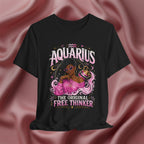 Black t-shirt with Aquarius design featuring a black woman and text 'The original free thinker' on a pink fabric background