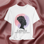 White t-shirt with a silhouette of a woman and 'Gemini Divinely Aligned' text on a pink fabric background