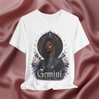 White t-shirt with 'Gemini' design featuring a black woman and floral elements on a maroon fabric background.