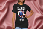 Person wearing a black t-shirt with American flag sunflower and 'TAURUS ENERGY' text on a textured pink background