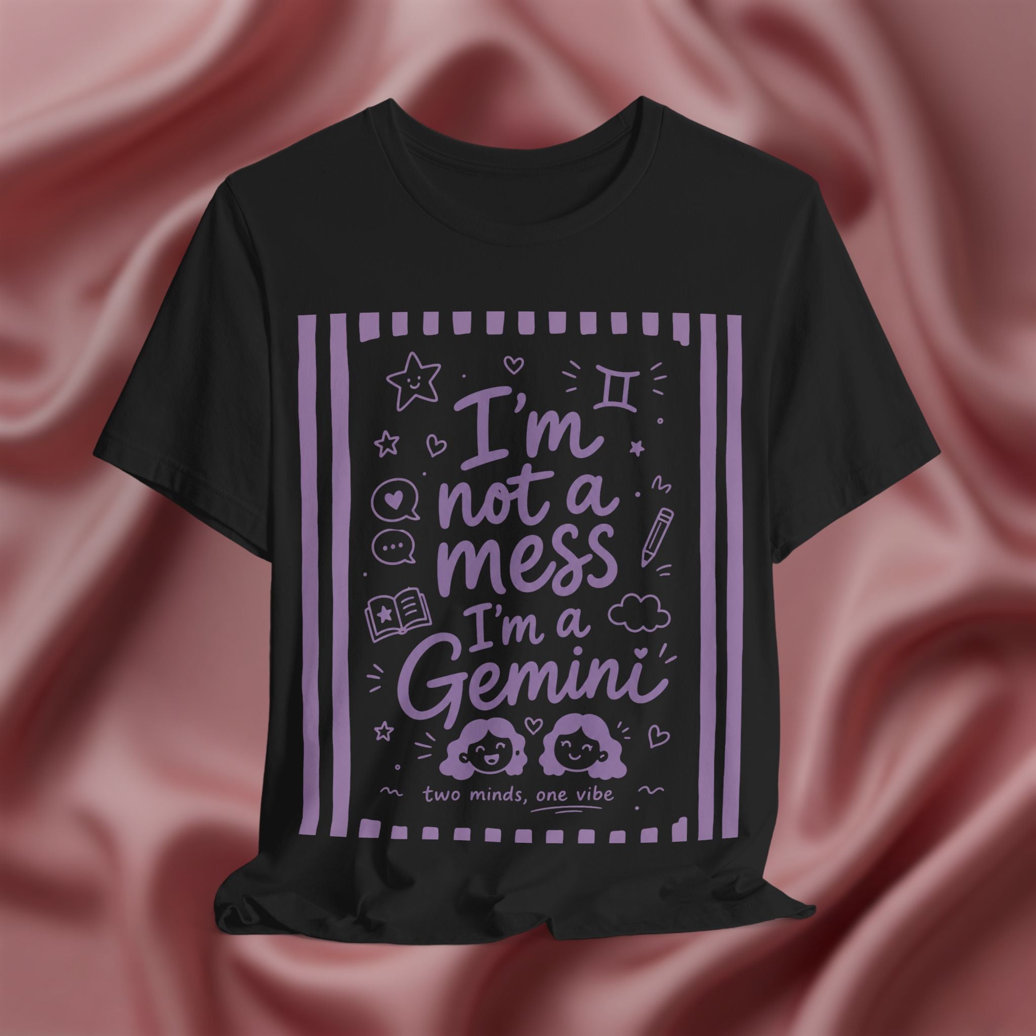 Black t-shirt with purple text 'I'm not a mess I'm a Gemini and graphics on a pink fabric background