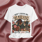 White t-shirt with 'Don't Rush Me, Taurus, Luxury Takes Time' design against a pink fabric background