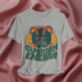 Gray t-shirt with Capricorn Energy design on a pink fabric background