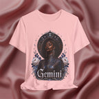 Pink t-shirt with a graphic design of a woman, flowers, and the word 'Gemini' on a pink fabric background.