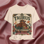 Soft cream T-shirt with Taurus zodiac design on a textured red background