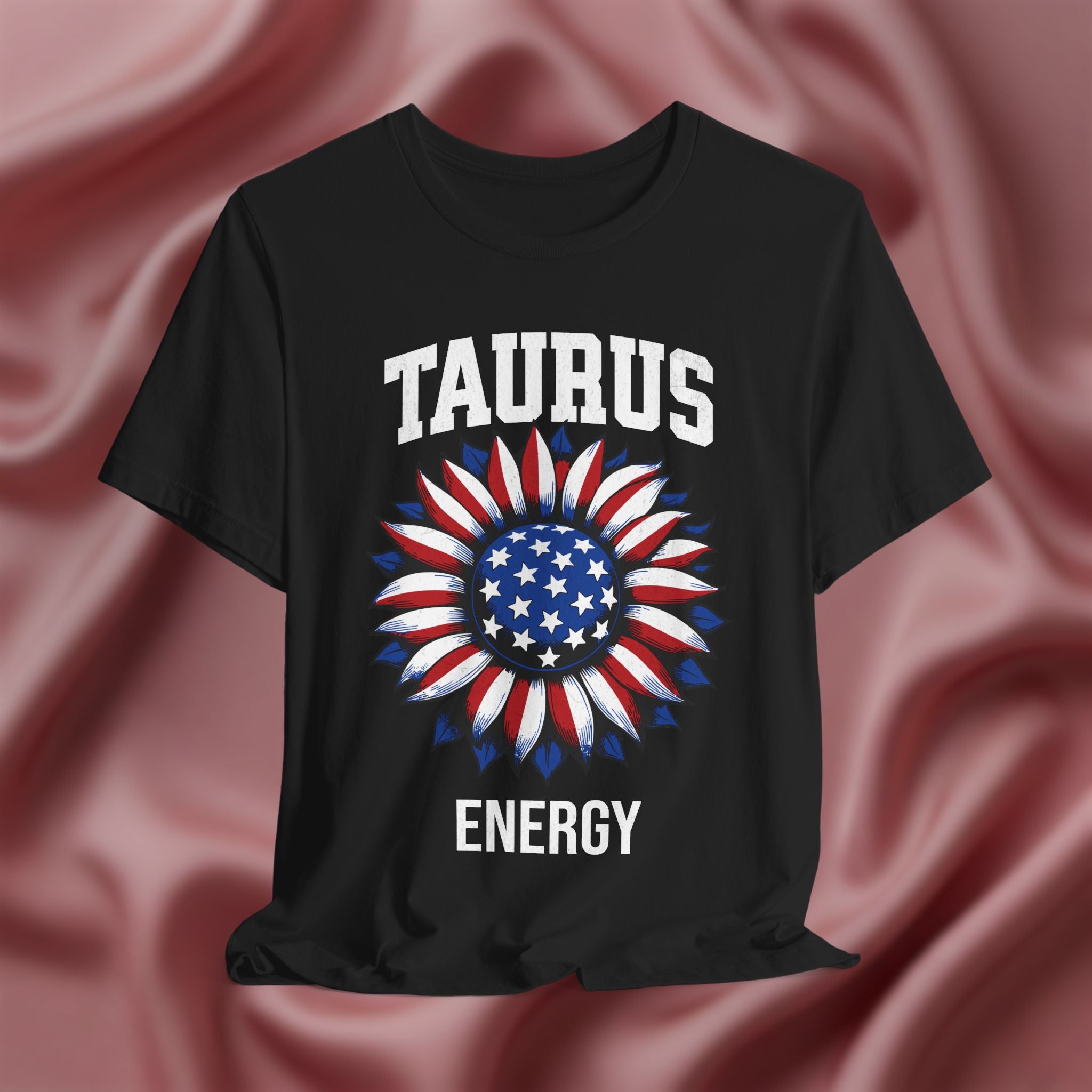 Black t-shirt with American flag sunflower and 'TAURUS ENERGY' text on a textured pink background