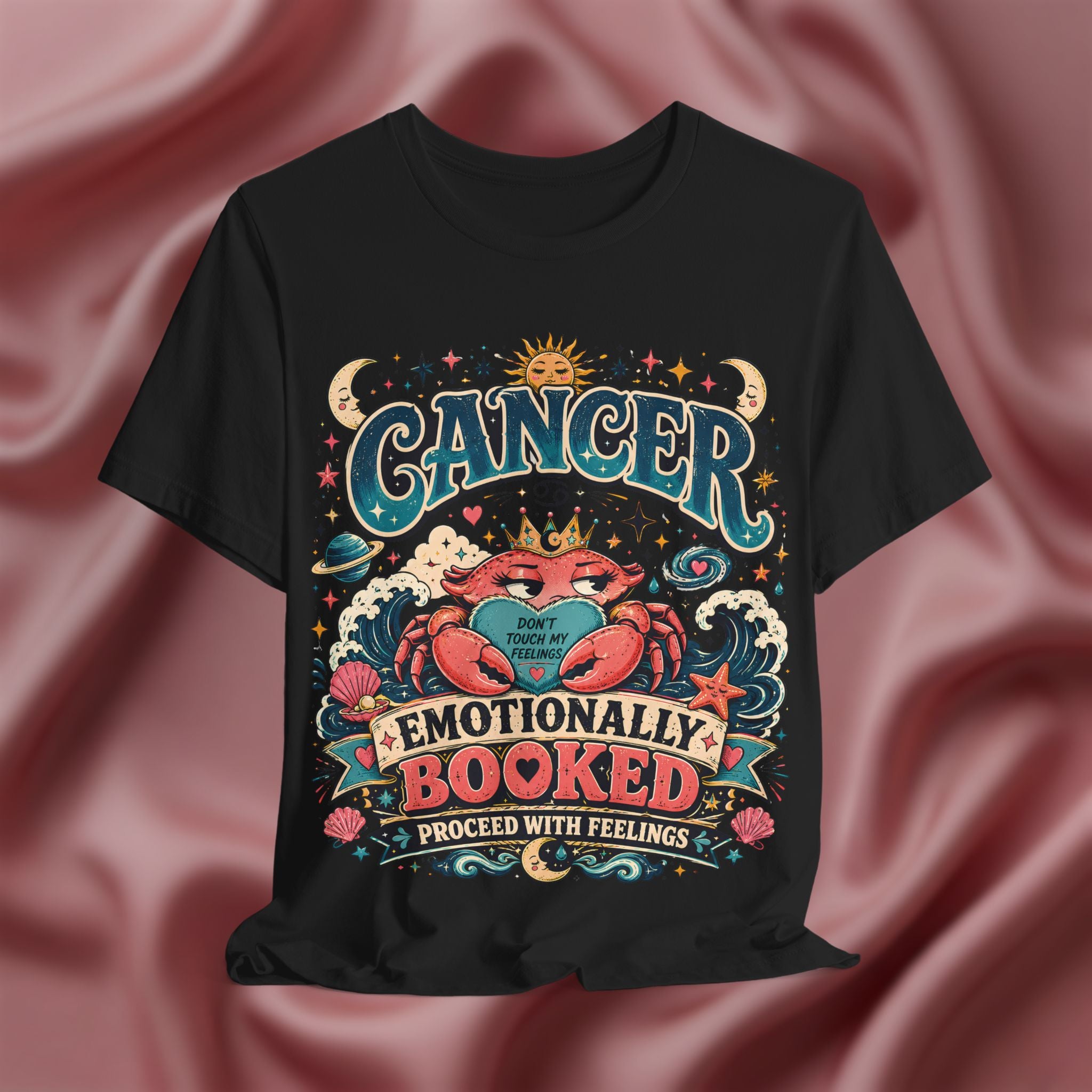 Black t-shirt with Cancer zodiac design on a pink fabric background
