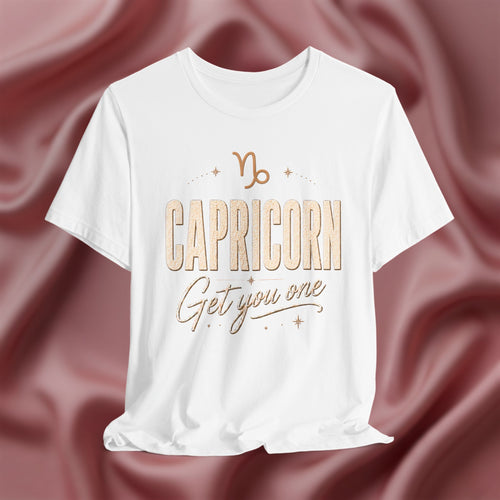 White t-shirt with 'Capricorn Get you one' text on a pink fabric background