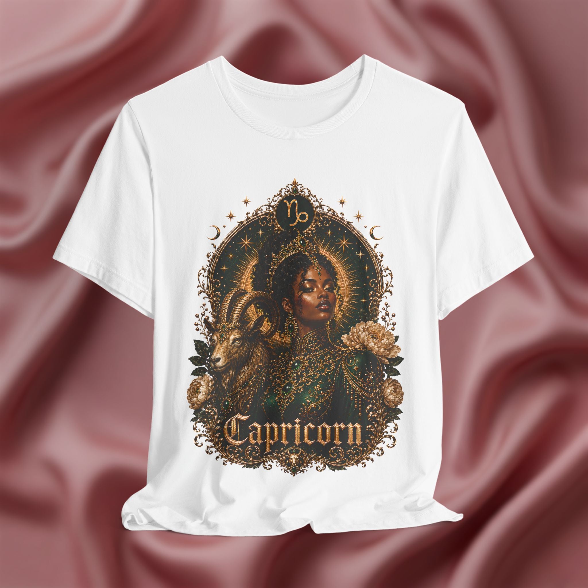 White t-shirt with Capricorn zodiac design on a maroon fabric background