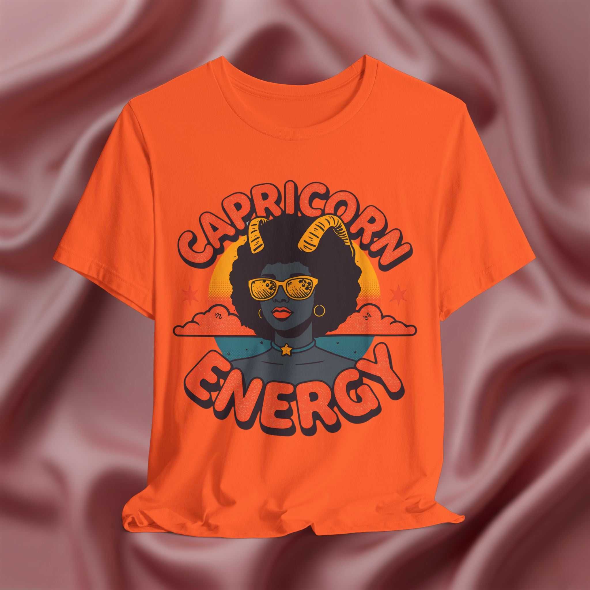 Orange t-shirt with 'Capricorn Energy' design on a textured brown background