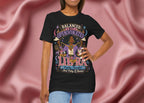 Person wearing a black t-shirt with Libra zodiac design on a pink fabric background