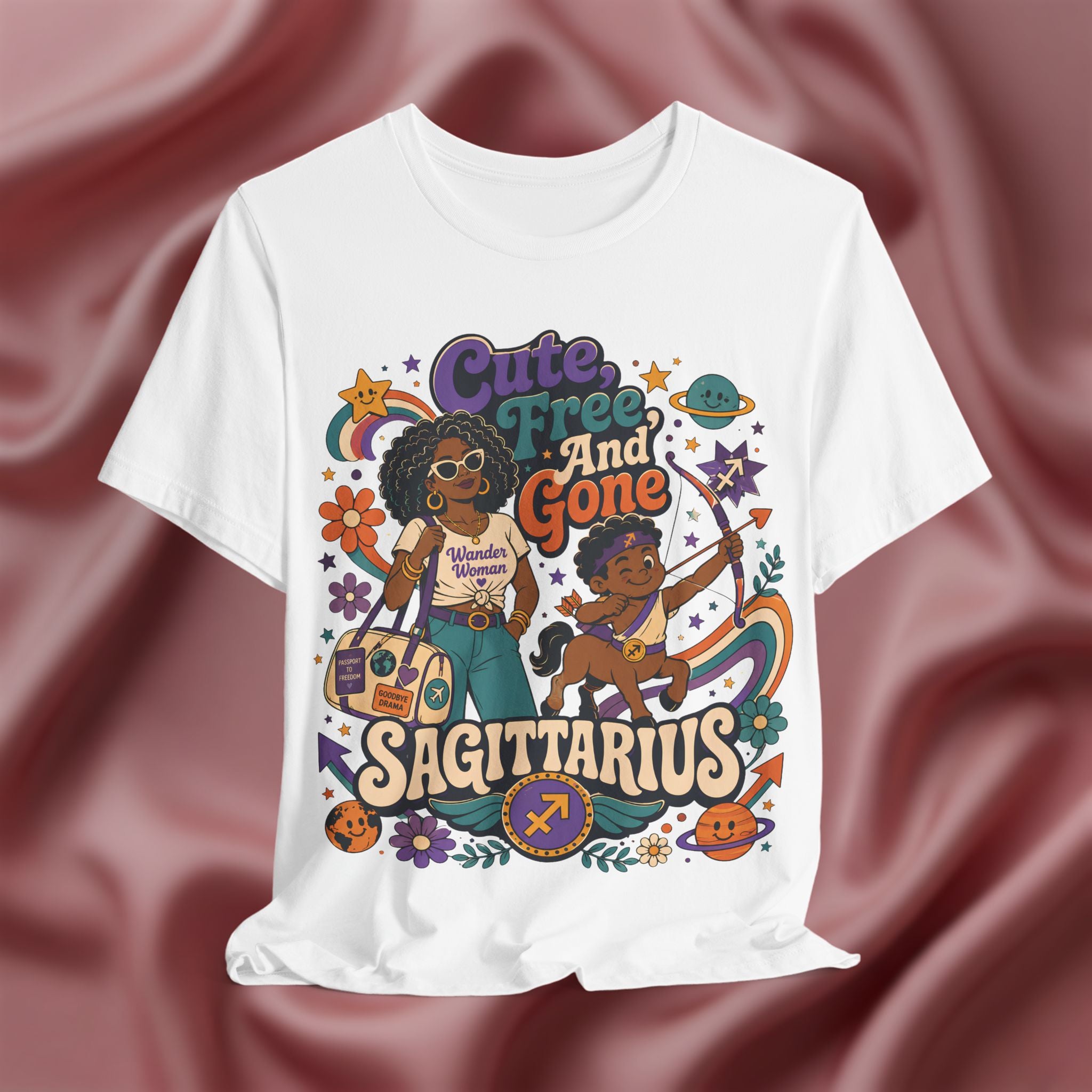 White t-shirt with colorful Sagittarius-themed design on a maroon fabric background