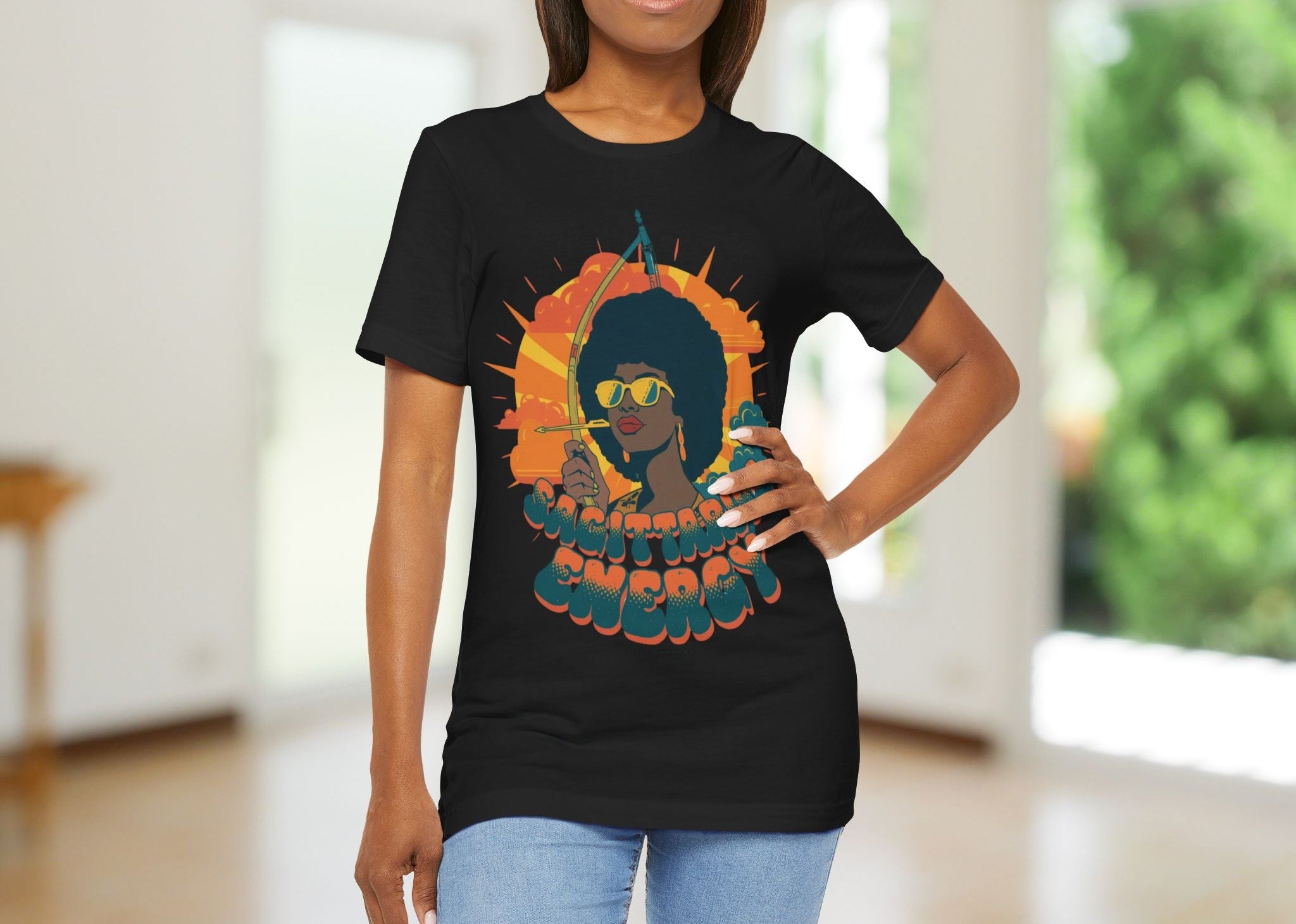 Woman wearing a black t-shirt with a graphic of a woman holding an arrow and the text 'Sagittarius Energy'