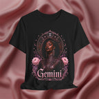 Black t-shirt with 'Gemini' design featuring a woman and floral elements on a pink fabric background.