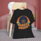 A black graphic t-shirt hanging on a wooden hanger from a light wood chair, set against a pink wall and gray wood floor. The graphic features a stylized portrait of a person with an afro, sunglasses, and the text 'VIRGO ENERGY' in orange and blue.