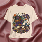 Soft cream T-shirt with Sagittarius zodiac design on a textured brown background