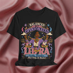 Black t-shirt with Libra zodiac design on a pink fabric background