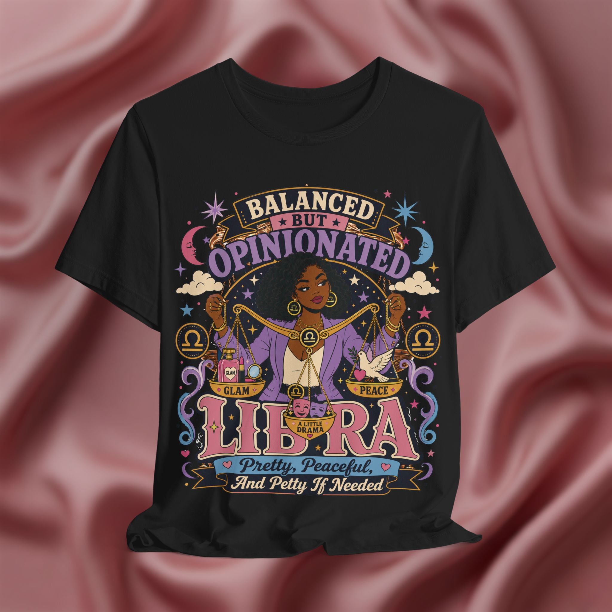 Black t-shirt with Libra zodiac design on a pink fabric background