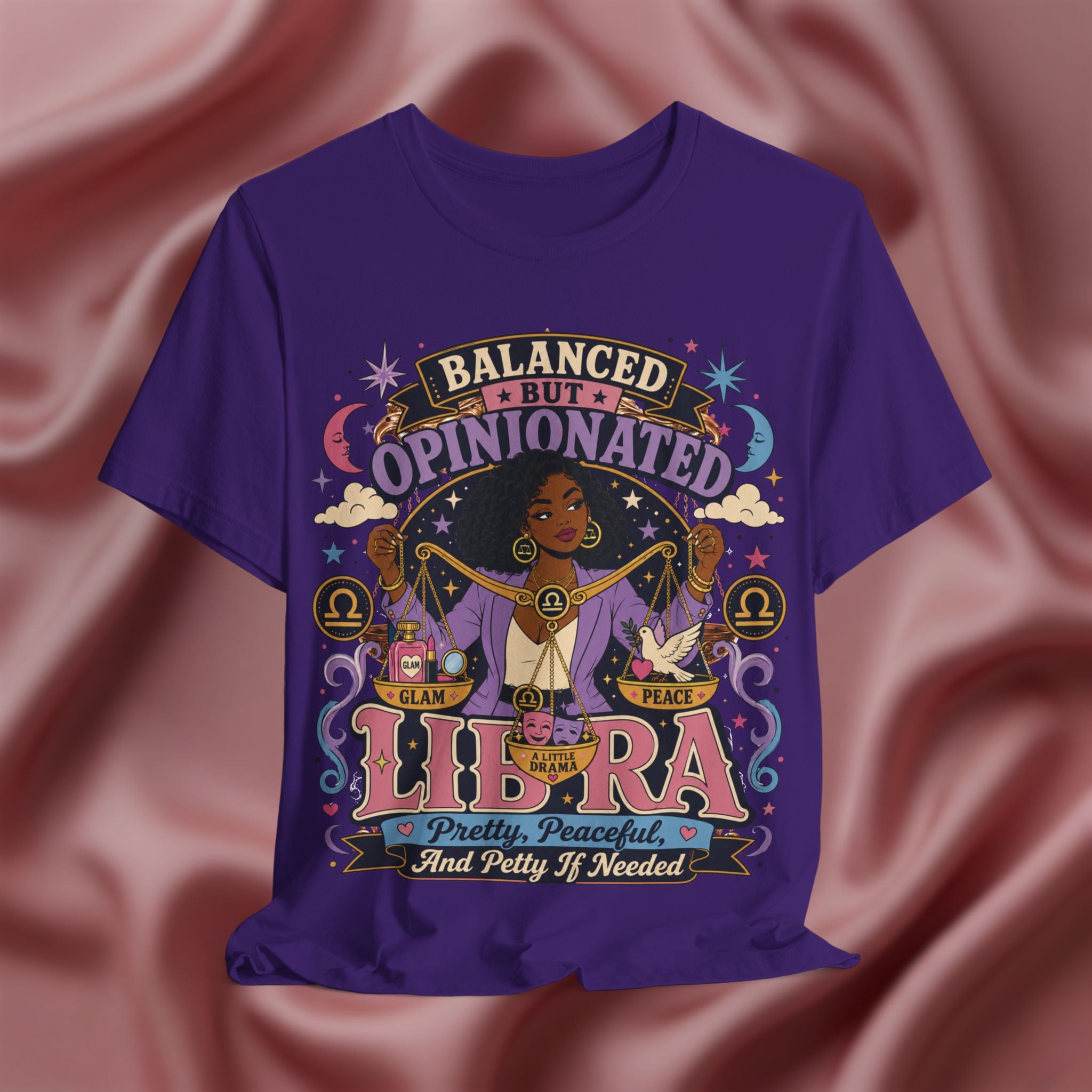 Purple t-shirt with Libra zodiac design on a pink fabric background