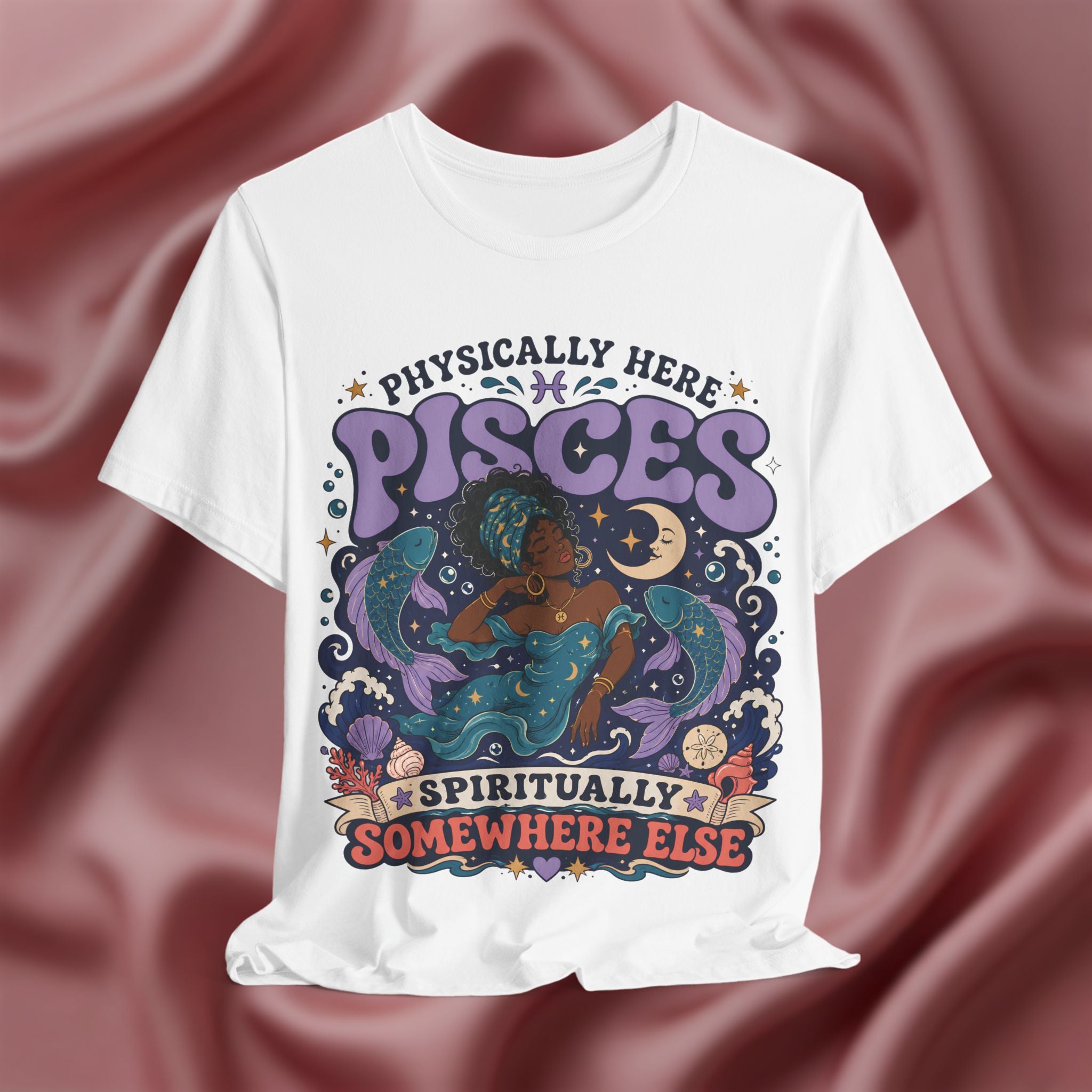 White t-shirt with colorful Pisces zodiac design on a maroon fabric background