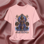Pink t-shirt with a 'Gemini' design featuring a woman in a blue dress on a maroon fabric background.