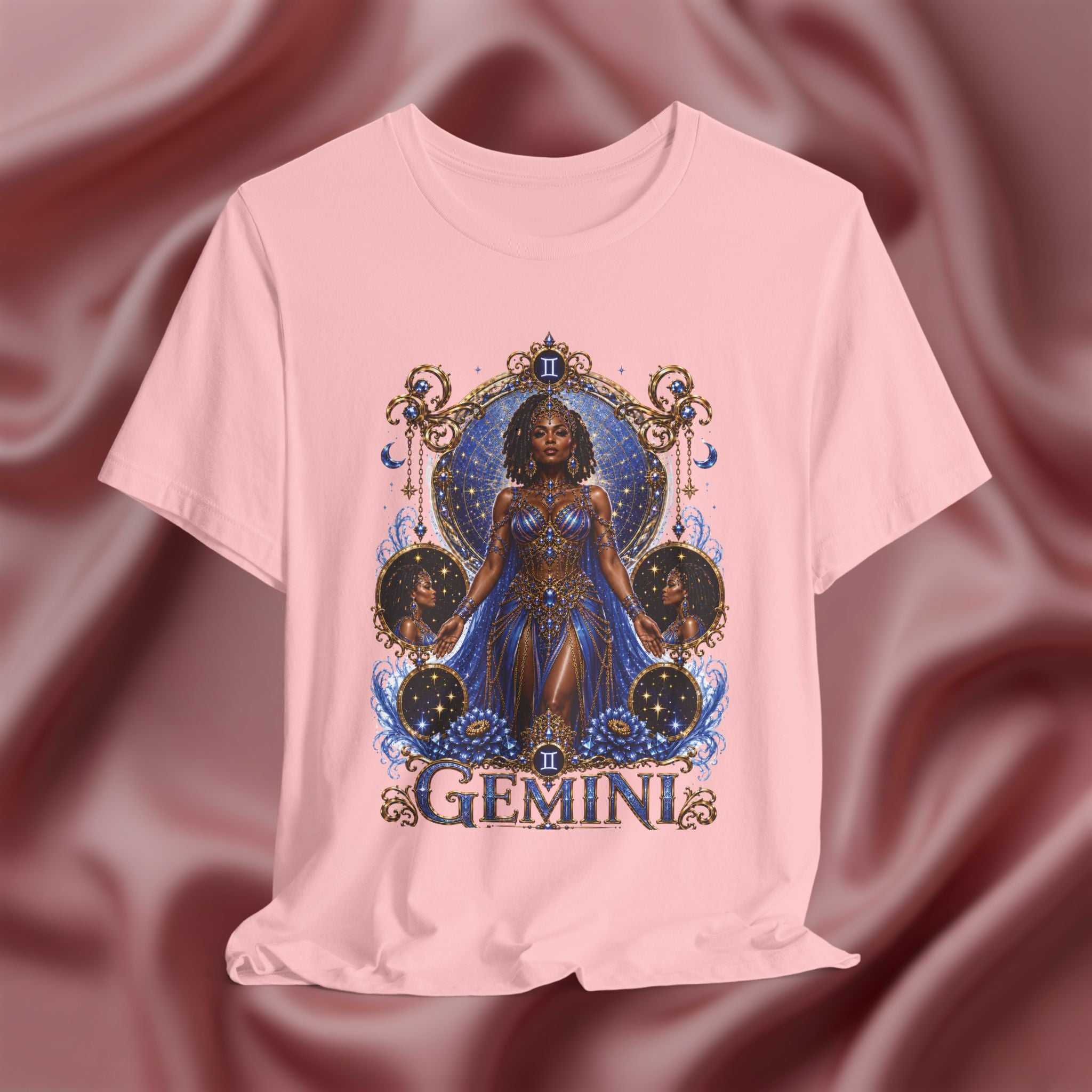 Pink t-shirt with a 'Gemini' design featuring a woman in a blue dress on a maroon fabric background.
