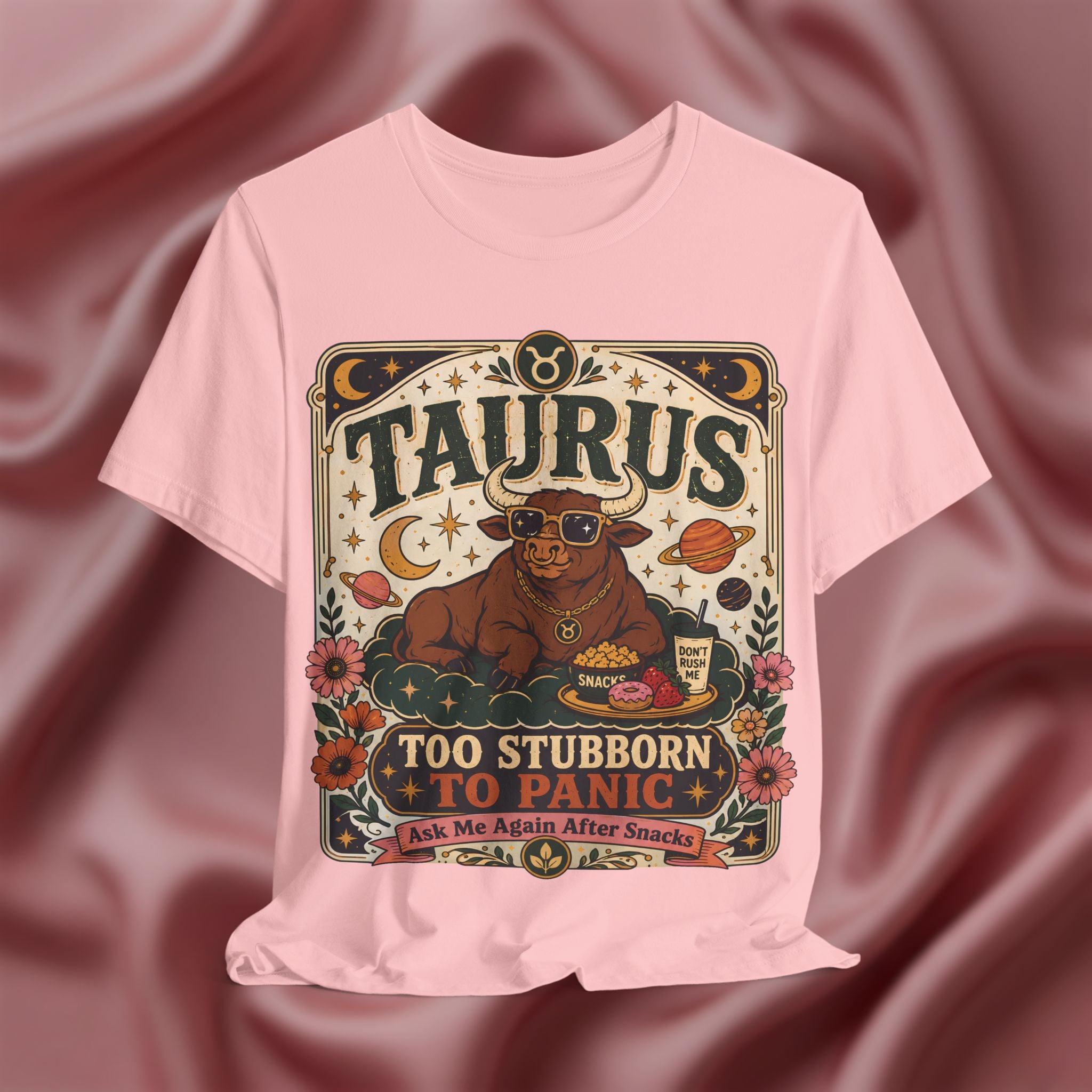 Pink T-shirt with Taurus zodiac design on a textured red background