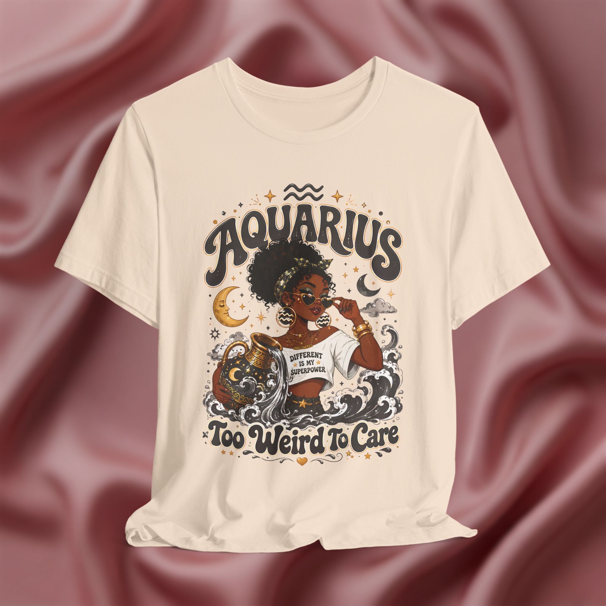 Cream t-shirt with 'Aquarius Too Weird To Care' design featuring a black woman wearing a t-shirt with the text 'different is my superpower' on a pink fabric background