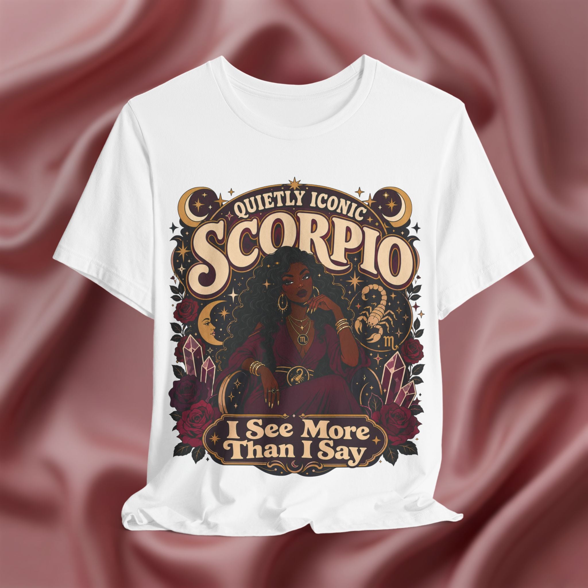 White t-shirt with Scorpio zodiac design on a maroon fabric background