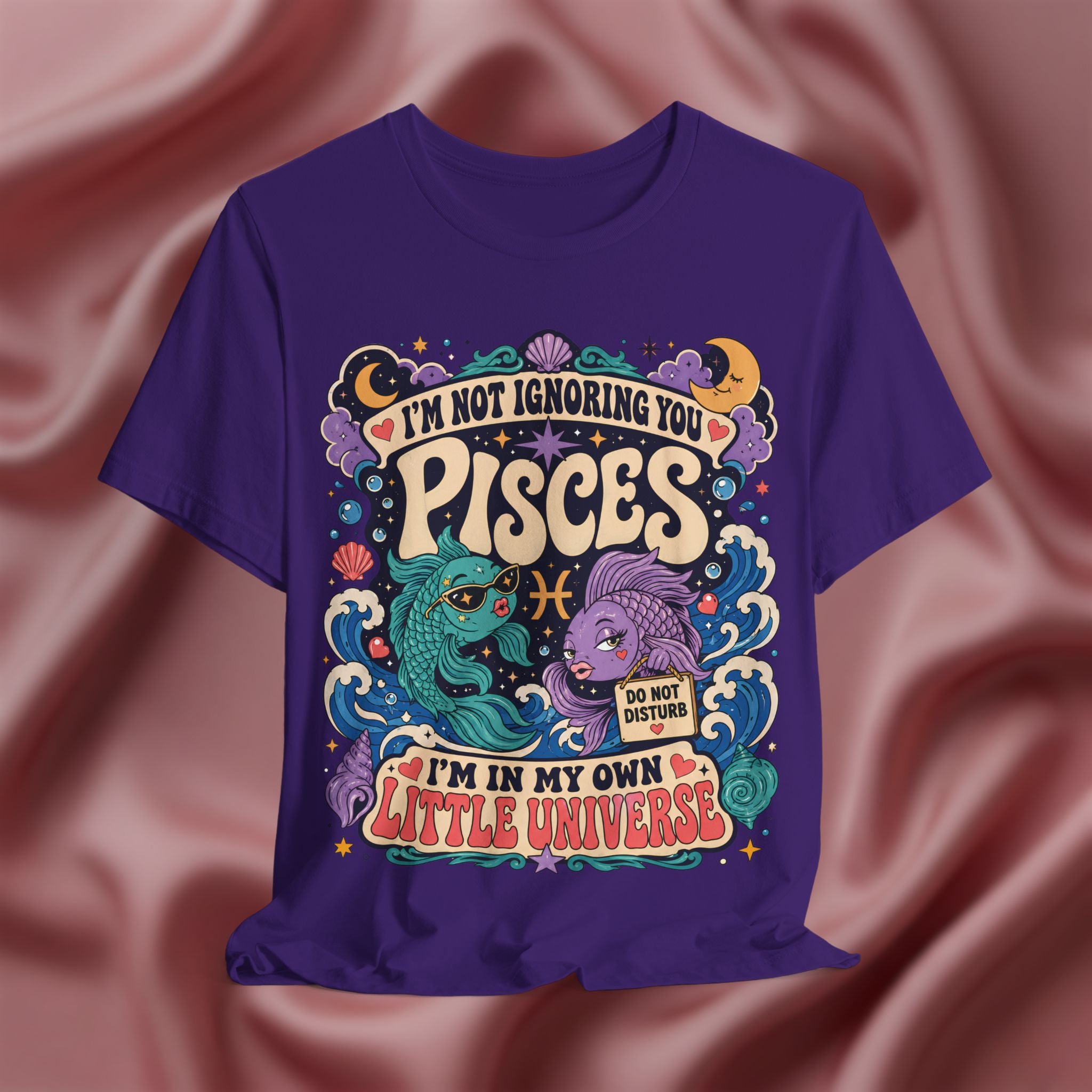 Purple t-shirt with Pisces zodiac design on a pink fabric background