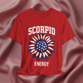 Red t-shirt with American flag sunflower and 'SCORPIO ENERGY' text on a textured pink background