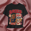 Black t-shirt with Aries zodiac design featuring a woman and ram on a pink fabric background