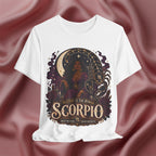 White t-shirt with Scorpio zodiac design on a maroon fabric background