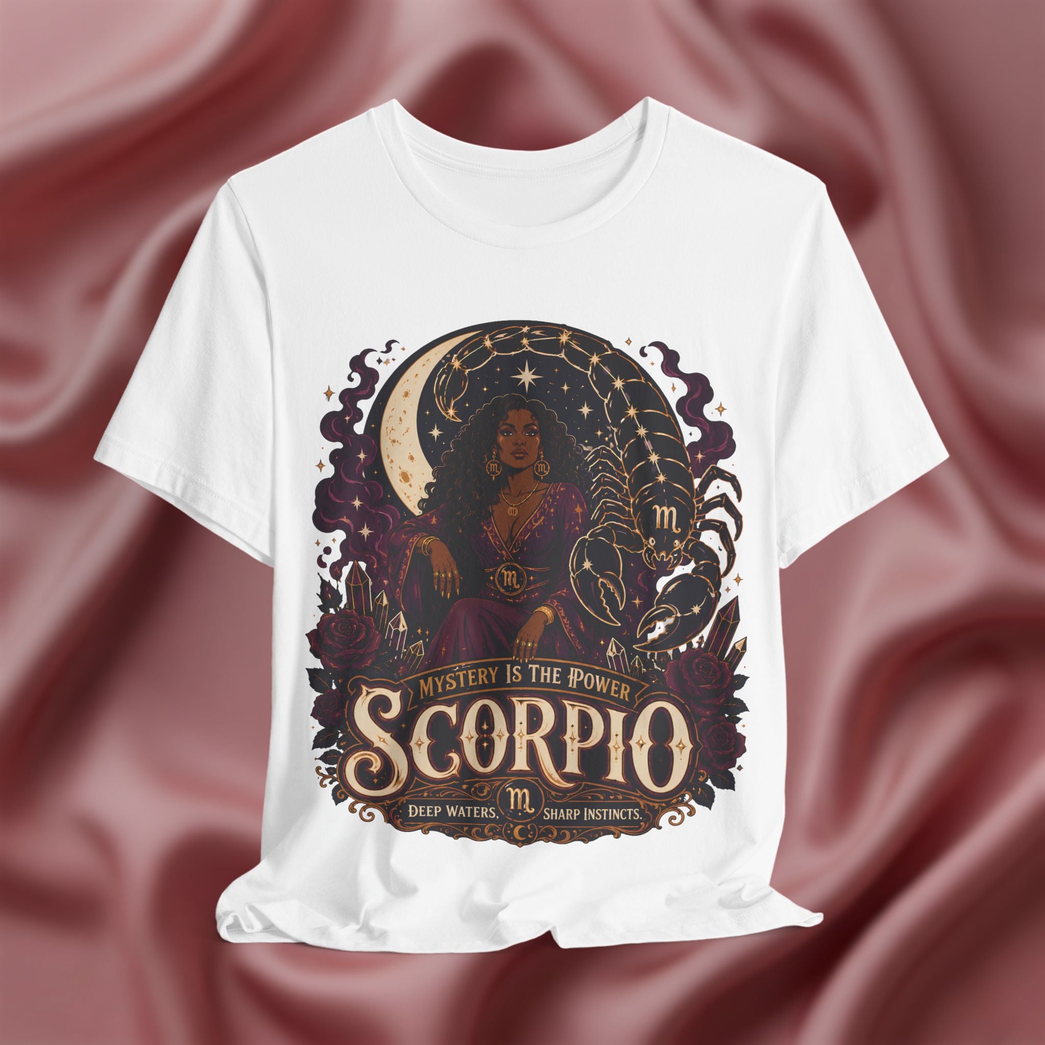 White t-shirt with Scorpio zodiac design on a maroon fabric background