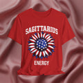 Red t-shirt with American flag sunflower and 'SAGITTARIUS ENERGY' text on a textured pink background