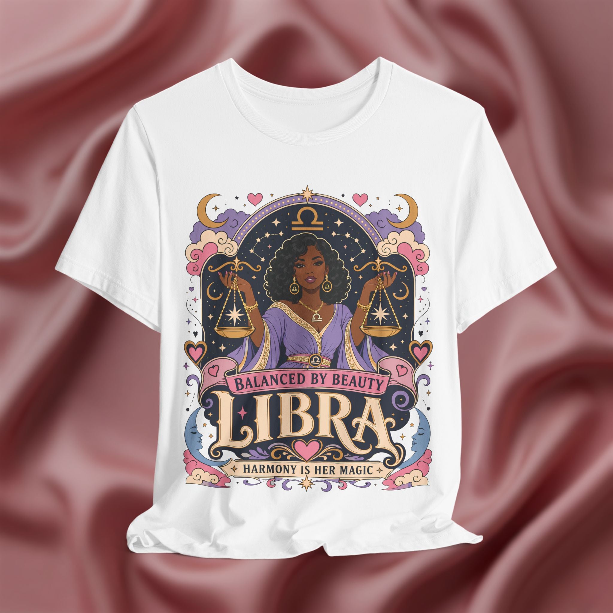 White t-shirt with Libra zodiac design on a maroon fabric background