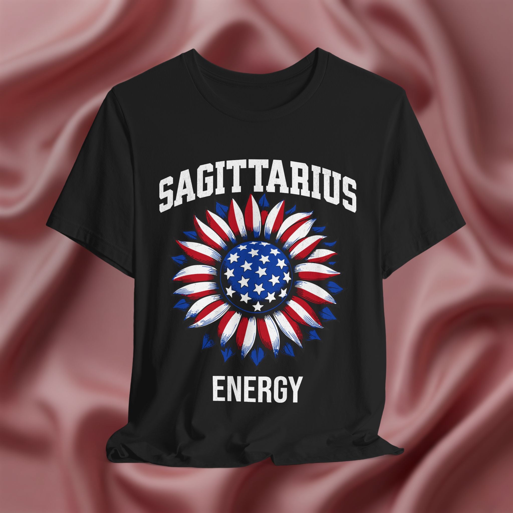 Black t-shirt with American flag sunflower and 'SAGITTARIUS ENERGY' text on a textured pink background