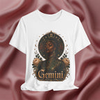 White t-shirt with a graphic design of a woman, flowers, and the word 'Gemini' on a pink fabric background.