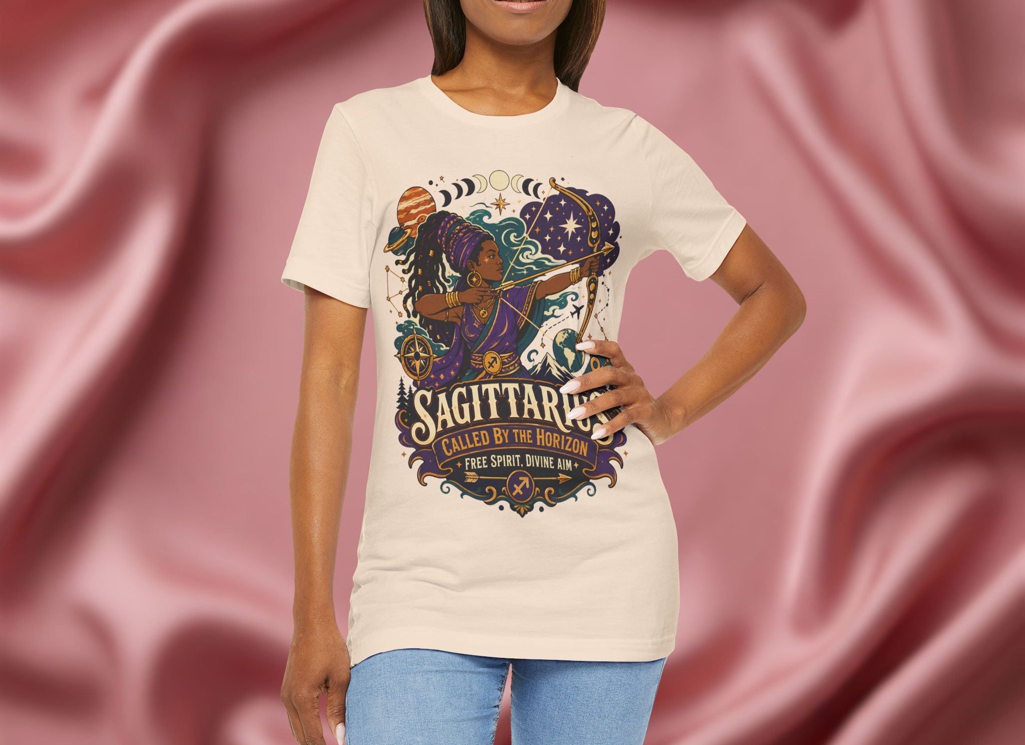 Person wearing a t-shirt with a Sagittarius design against a pink fabric background