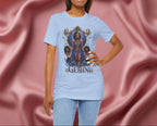 Woman wearing a light blue t-shirt with a graphic design and the word 'GEMINI' on a pink fabric background