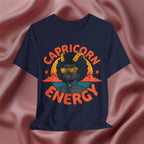 Navy blue t-shirt with 'Capricorn Energy' design on a pink fabric background