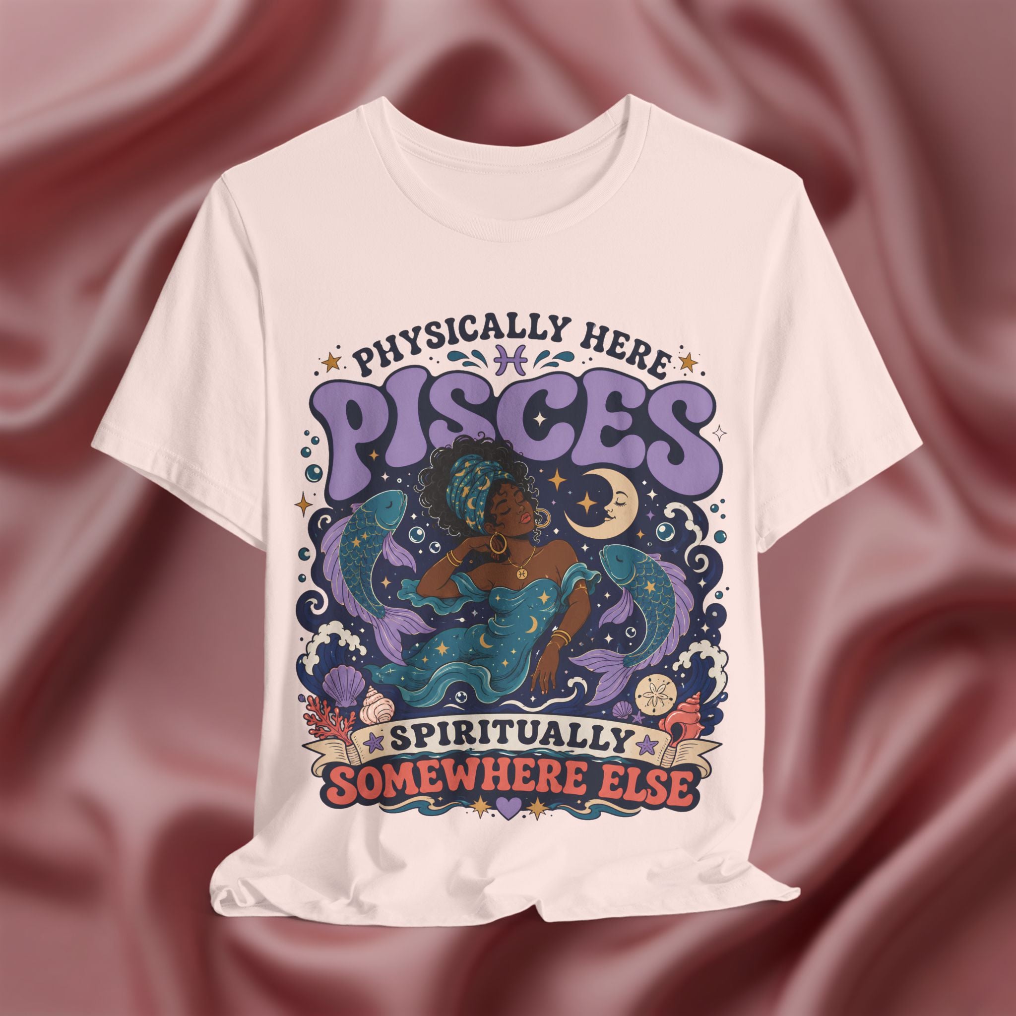 White t-shirt with Pisces zodiac design on a maroon fabric background