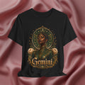 Black t-shirt with a graphic design of a woman, flowers, and the word 'Gemini' on a pink fabric background.