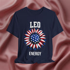 Navy blue t-shirt with American flag sunflower and 'LEO ENERGY' text on a textured pink background