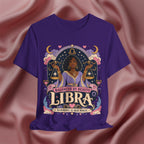 Purple t-shirt with Libra zodiac design on a pink fabric background