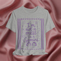 Gray t-shirt with purple text 'I'm not a mess I'm a Gemini and graphics on a pink fabric background