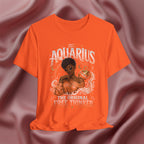 Orange t-shirt with Aquarius design featuring a black woman and text 'The original free thinker' on a pink fabric background